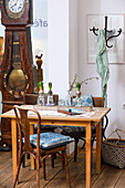 Wooden table with chairs, hyacinth glasses and antique grandfather clock