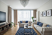 Wohnzimmer im Hampton-Stil, hellgraue Sofagarnitur und blaue Accessoires