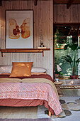 Doppelbett vor Holzwand im Schlafzimmer