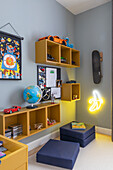 Children's room with yellow shelving elements and blue walls