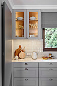 White and grey kitchen with illuminated cabinet