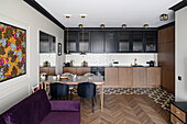 Open plan living room with fitted kitchen cabinets, dining area and dark purple sofa