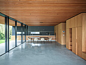 Open kitchen and dining area with wooden elements and concrete floor