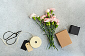 Carnations, ribbon, paper tags, and small box
