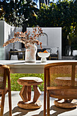Tisch mit Stühlen auf sonniger Terrasse