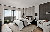 Modern bedroom in neutral tones, floor to ceiling upholstered headboard
