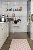 Moderne Küche mit Rückwand in Marmoroptik und Hängeleiste für Küchenutensilien