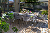 Wooden terrace with modern dining table and chairs