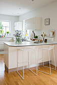 Bright kitchen with counter and metal bar stools