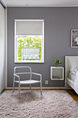 Minimalistisches Schlafzimmer mit grauen Wänden und flauschigem Teppich