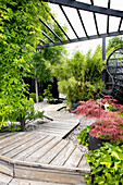 Asian-inspired garden with wooden walkway and pergola