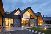 Modernes Architektenhaus mit Zinkdach, Blick in beleuchtete Innenräume