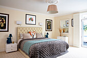 Bright bedroom with upholstered headboard and colorful accents