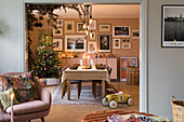 Festlich gedeckter Esstisch im skandinavischen Stil mit Weihnachtsbaum im Hintergrund