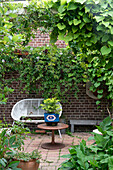 Small seating area in the patio with brick wall and climbing plants