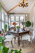 Wooden dining table with candlestick and plants in the country dining room