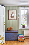 Vintage chest, basket and mural, green plant on windowsill