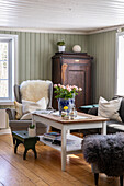 Wohnzimmer mit Vintage-Schrank und Blumendekoration auf Holztisch