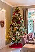 Decorated Christmas tree in the dining room with festive table
