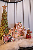 Weihnachtlich dekorierter Kaminsims mit Lebkuchenhäuschen und Figuren