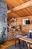 Holzverkleidetes Wohnzimmer mit Kaminholz-Lager und Klinkerwand