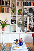 Living room with shelves, marble column and marble table and colorful decorative elements