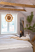 Schlafzimmer im Dachgeschoss mit Doppelbett, Holzbalken und weihnachtlicher Dekoration