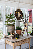 Winter decorations on wooden table with Christmas tree, reindeer figurine and candles