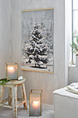 Christmas home decorations with illuminated fir tree picture, lanterns and wooden stool