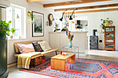 Living room with wooden beams, colorful rug and country-style stove