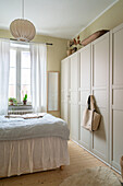Bright bedroom with large wardrobe and natural-coloured accents