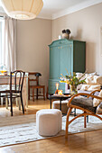 Heller Wohnbereich mit grünem Vintage-Schrank und Holzmöbeln