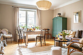 Bright living room with dining table, vintage cupboard and seating area