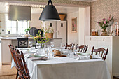 Country-style dining table with decorative branches and pendant light