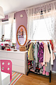 Children's room with clothes rail and wall mirror