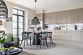 Modern kitchen with dining area, rattan lights and light-coloured fronts