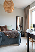 Bedroom with rattan pendant light and work area