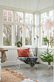 Armchair with fur and Christmas decorations in a bright room with lots of windows