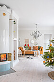 Bright living room with fireplace, Christmas tree and metallic chandelier