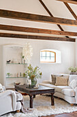 Bright living room with wooden beamed ceiling and vintage coffee table