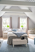 Bedroom with sloping ceiling and blue and white striped wallpaper