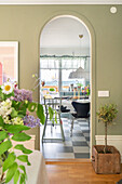 Passageway to the dining area with table and black-grey tiled floor