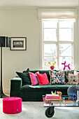 Modern living room with green velvet sofa and colourful decorative cushions