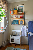 Children's room corner with play kitchen, wall shelf and creative decoration