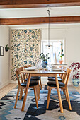 Set table, chairs, patterned curtain and patterned carpet in dining room