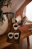 Person pouring coffee into cups