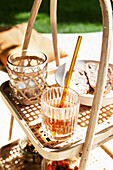 Drink and slices of bread on a rattan side table in the garden