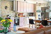 Kitchen with pink cabinets, mosaic tiles and wallpaper with floral pattern