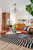 Living room with leather couch, fireplace and striped carpet