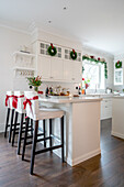 White kitchen with Christmas decorations and bar stools